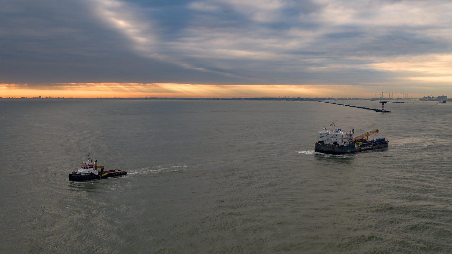 Tugboat Neptune Foxtrot towing a barge at sunset Tugboat Neptune Foxtrot towing a barge at sunset